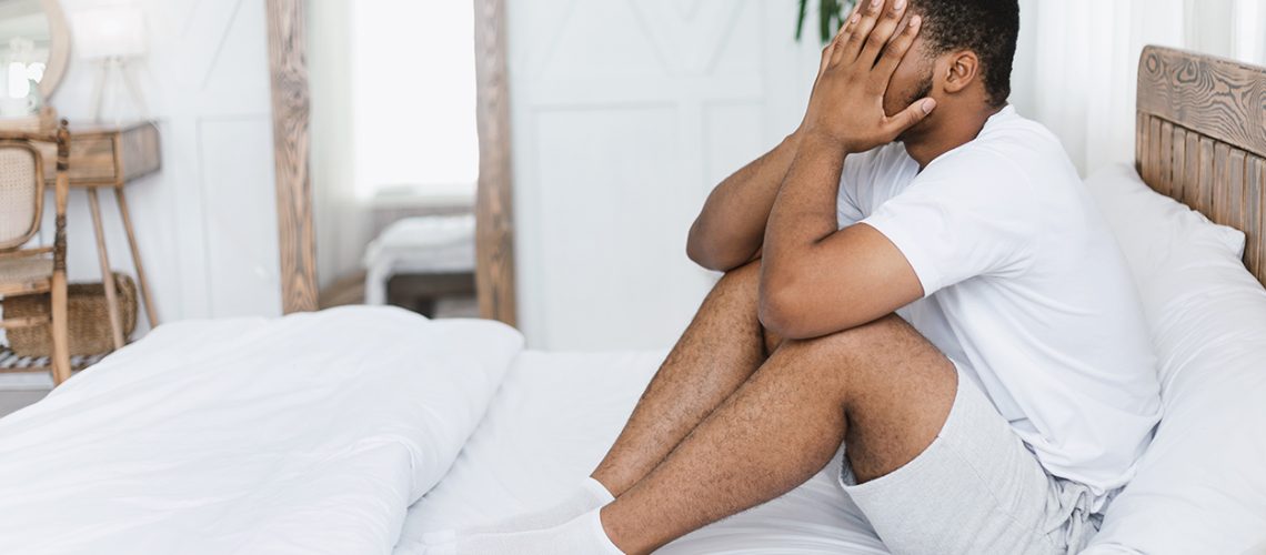 Headache Pain. African American Guy Touching Aching Head Suffering From Ache Sitting In Bed At Home. Health Problem, Painful Migraine, Male Anxiety And Insomnia Concept. Copy Space
